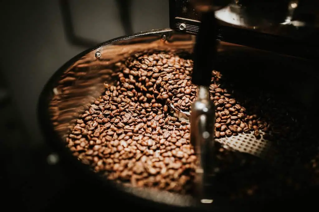 Freshly roasted coffee beans being prepared in a coffee machine.