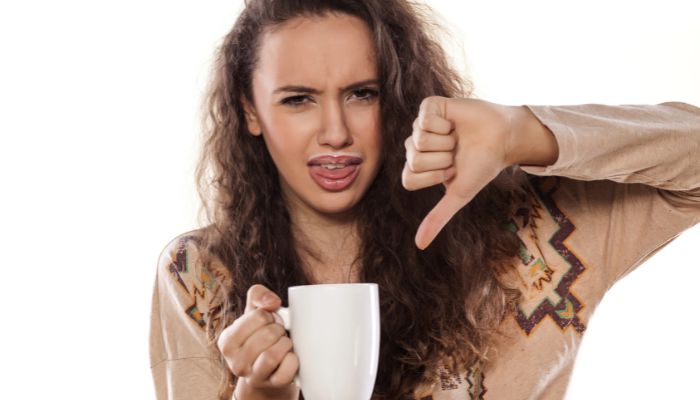 Woman with a cup of coffee she doesn't like