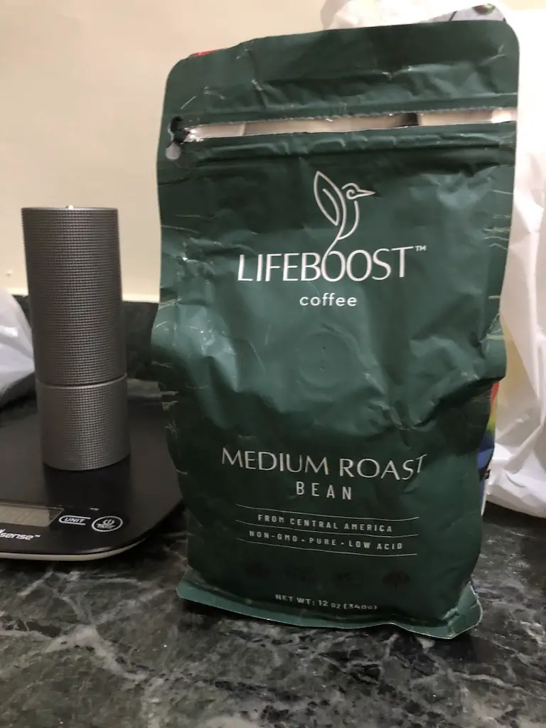 bag of lifeboost coffee next to grinder